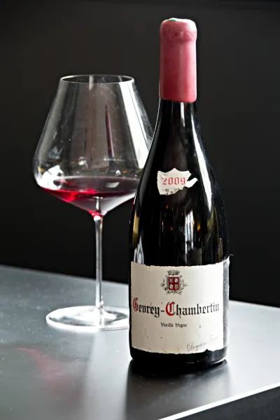 Une bouteille de Gevrey-Chambertin avec un verre de dégustation à ses côtés